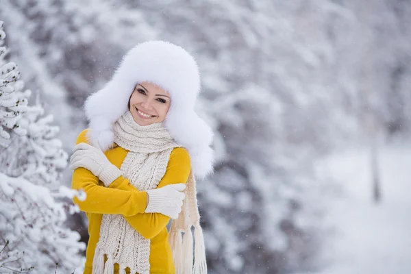 Menina bonita em um chapéu fofo branco na neve — Fotografia de Stock
