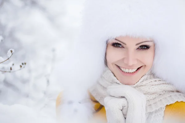 美丽的女孩在雪地上的白色蓬松帽子 — 图库照片