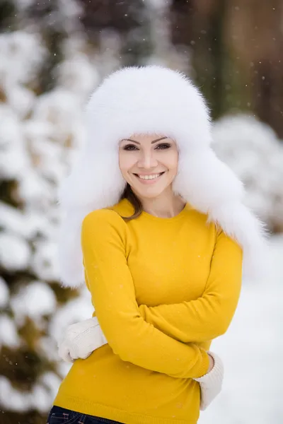 Beautiful girl in a white fluffy hat on snow — Stock Photo, Image