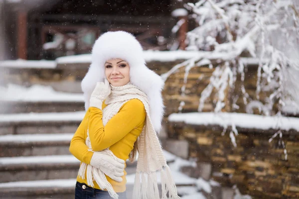 Krásná dívka v bílém nadýchané klobouku na sněhu — Stock fotografie
