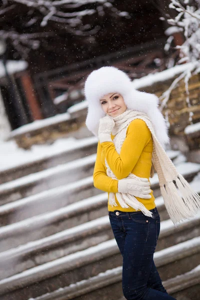 Όμορφο κορίτσι σε ένα λευκό αφράτο καπέλο στο χιόνι — Φωτογραφία Αρχείου