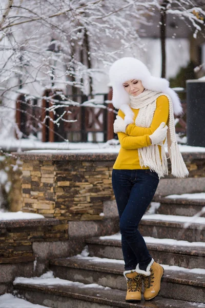 美丽的女孩在雪地上的白色蓬松帽子 — 图库照片