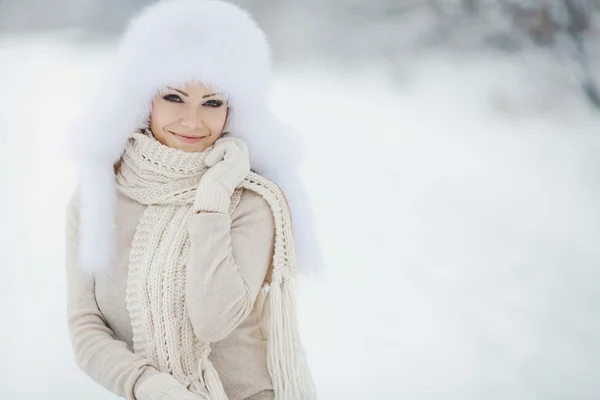 Krásná dívka v bílém nadýchané klobouku na sněhu — Stock fotografie