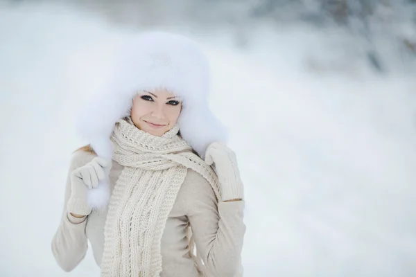 Gyönyörű lány, egy fehér puha kalap, hó — Stock Fotó