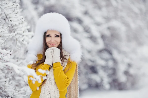 Menina bonita em um chapéu fofo branco na neve Imagens Royalty-Free