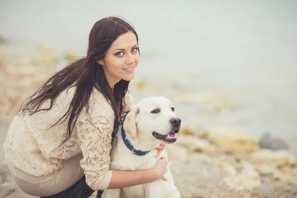 Portret pięknej młodej kobiety gry z psem nad morzem — Zdjęcie stockowe