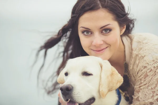 Retrato de bela jovem mulher brincando com o cão no mar — Fotografia de Stock