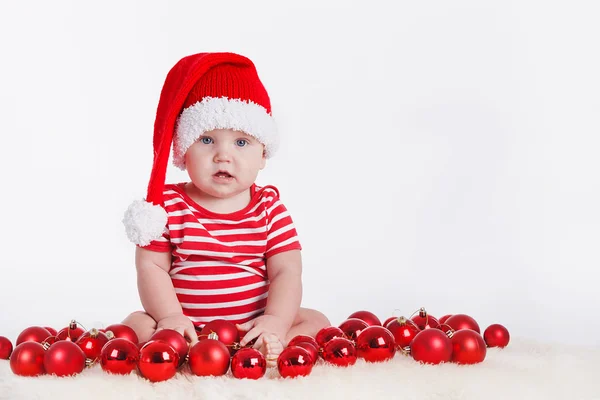 Entzückendes Kind in Weihnachtsmütze mit Stapeln von Geschenkkartons herum — Stockfoto