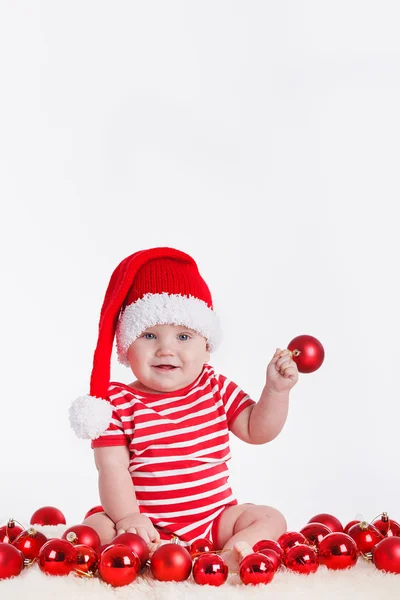 Adorabile bambino in berretto di Babbo Natale con pile di scatole presenti intorno — Foto Stock