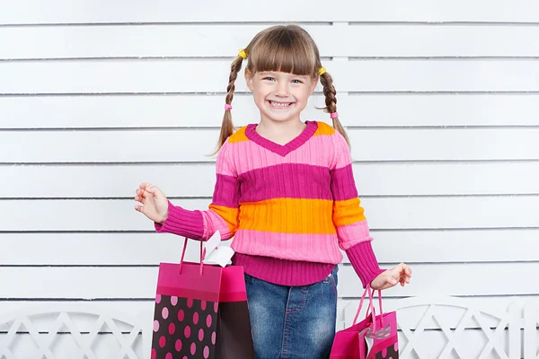 Kleines Mädchen sitzt auf Bücherstapel — Stockfoto