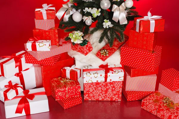 Різдвяні подарунки в червоних коробках на червоному тлі — стокове фото