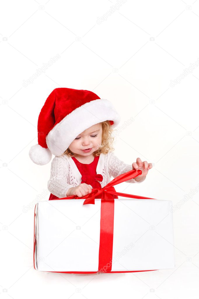 Child holding present wearing santa hat isolated on white