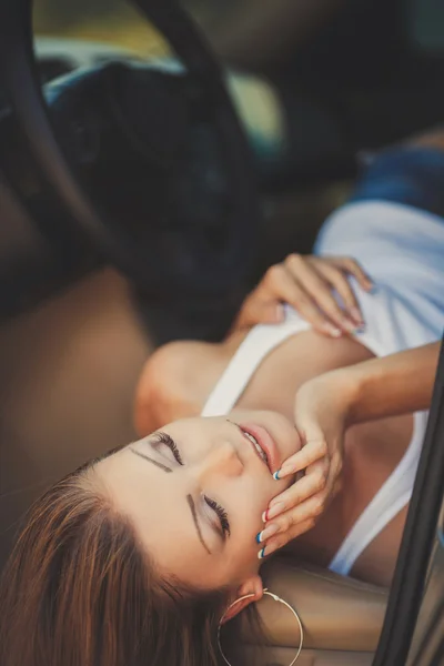 Portrait of beautiful sexy fashion woman model with bright makeup sitting in a car — Stock Photo, Image