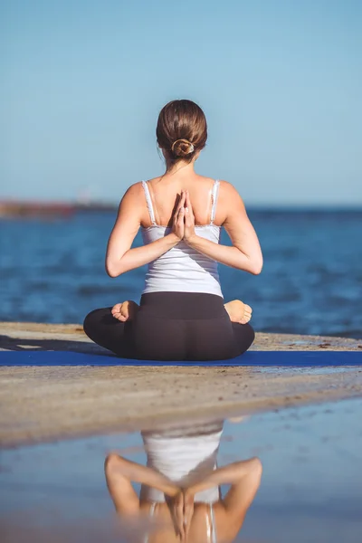 Genç kadın, deniz kıyısında, yoga egzersizleri — Stok fotoğraf