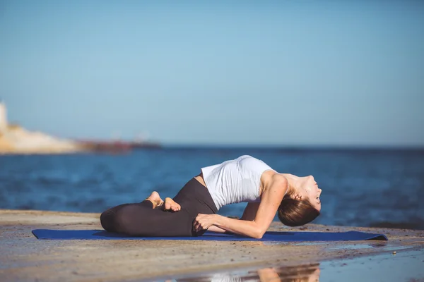 Genç kadın, deniz kıyısında, yoga egzersizleri — Stok fotoğraf