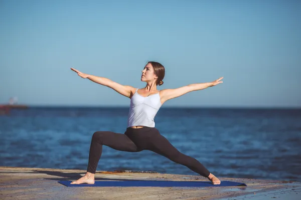 Genç kadın, deniz kıyısında, yoga egzersizleri — Stok fotoğraf