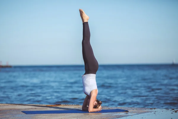 Mujer joven, orilla del mar, ejercicios de yoga — Foto de Stock