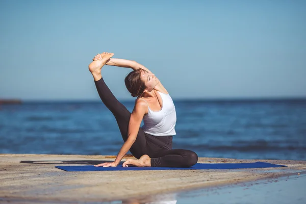 Genç kadın, deniz kıyısında, yoga egzersizleri — Stok fotoğraf