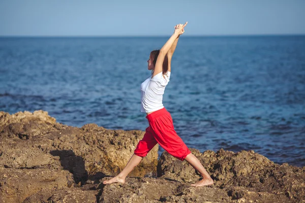 Mujer joven, orilla del mar, ejercicios de yoga —  Fotos de Stock