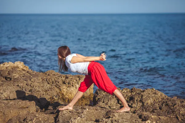 Genç kadın, deniz kıyısında, yoga egzersizleri — Stok fotoğraf