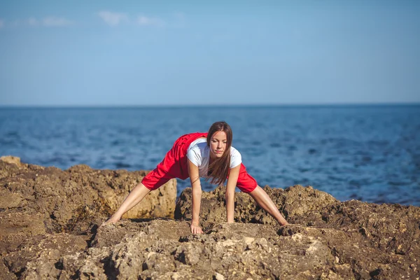 Mladá žena, mořské pobřeží, cvičení jógy — Stock fotografie