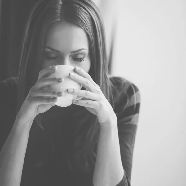 Mulher bonita sentada em um café com uma xícara de chá — Fotografia de Stock