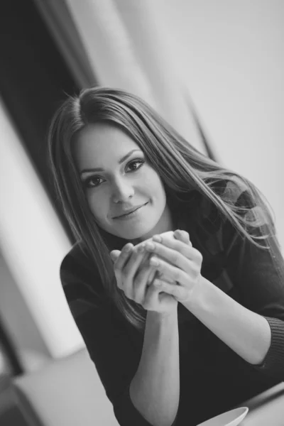 Bella giovane donna seduta in un caffè con una tazza di tè — Foto Stock