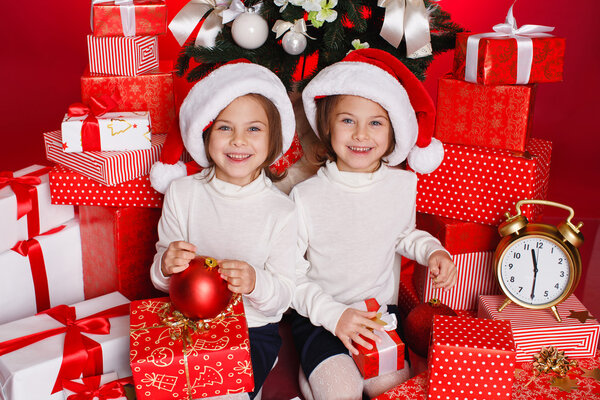 Happy teen sisters decorating Christmas tree