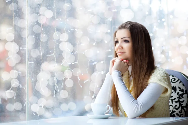 Mujer joven y bonita sentada en el café con una taza de café — Foto de Stock