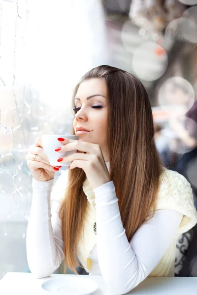 Söt ung kvinna sitter i caféet med en kopp kaffe — Stockfoto