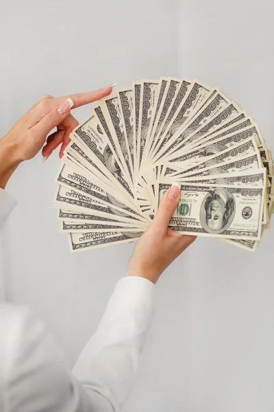 A young woman with dollars in her hands, isolated on white — Stock Photo, Image