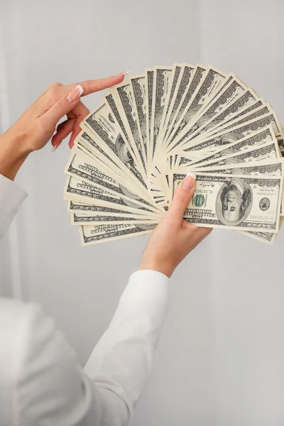 A young woman with dollars in her hands, isolated on white — Stock Photo, Image