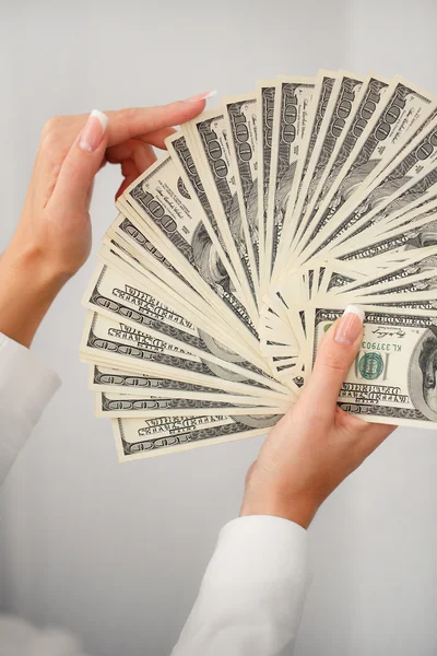 A young woman with dollars in her hands, isolated on white — Stock Photo, Image