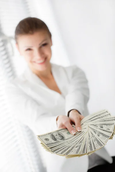 A young woman with dollars in her hands, isolated on white — Stock Photo, Image