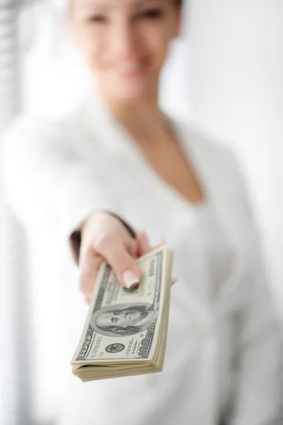 A young woman with dollars in her hands, isolated on white — Stock Photo, Image