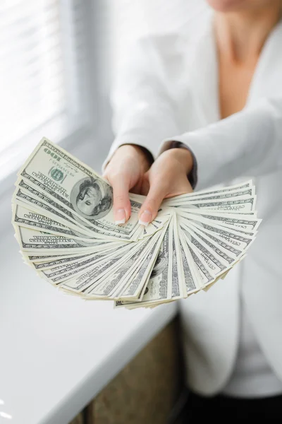 A young woman with dollars in her hands, isolated on white — Stock Photo, Image