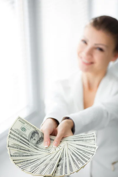 A young woman with dollars in her hands, isolated on white — Stock Photo, Image