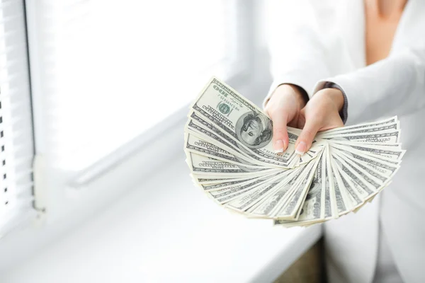 A young woman with dollars in her hands, isolated on white — Stock Photo, Image