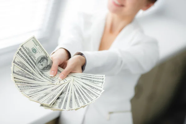 A young woman with dollars in her hands, isolated on white — Stock Photo, Image