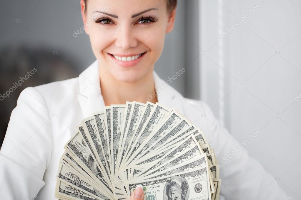 A young woman with dollars in her hands, isolated on white
