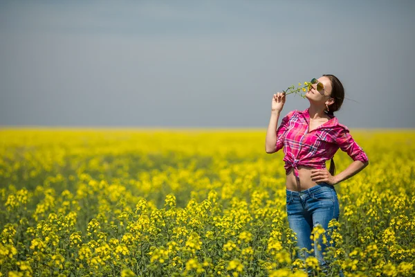 Mladá krásná žena v poli kvetoucí v létě. venkovní — Stock fotografie