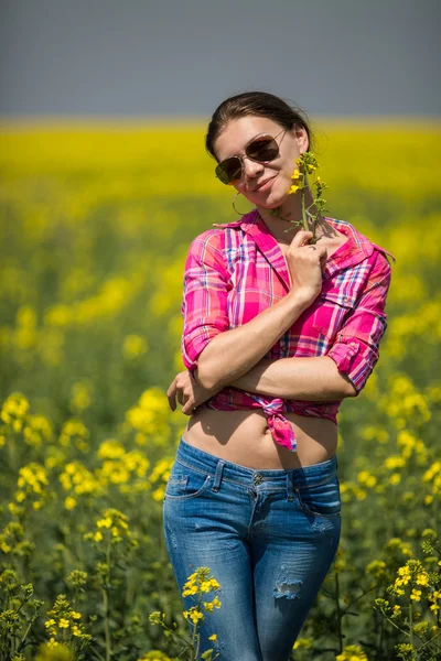 Young beautiful woman in flowering field in summer. Outdoors — Stock Photo, Image