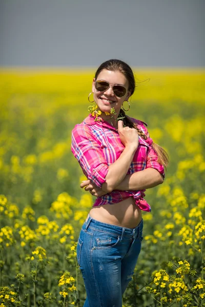 Mladá krásná žena v poli kvetoucí v létě. venkovní — Stock fotografie