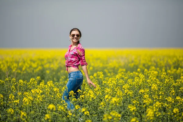 Young beautiful woman in flowering field in summer. Outdoors — Stock Photo, Image