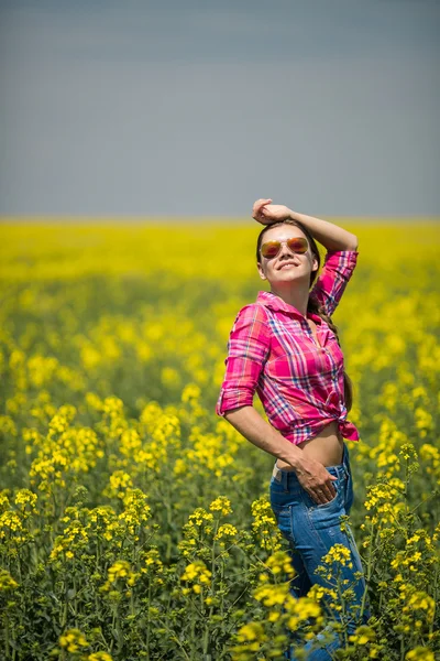 Mladá krásná žena v poli kvetoucí v létě. venkovní — Stock fotografie