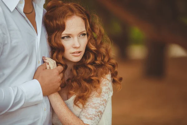 Retrato de una joven pelirroja hermosa de pie en el verde parque de verano — Foto de Stock