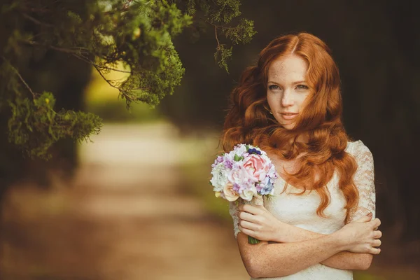 Ritratto di giovane bella donna dai capelli rossi in piedi nel verde del parco estivo — Foto Stock