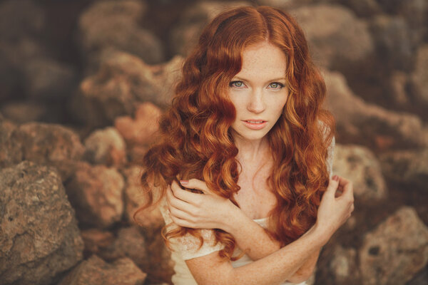 Portrait of young beautiful redhair woman standing in green summer park