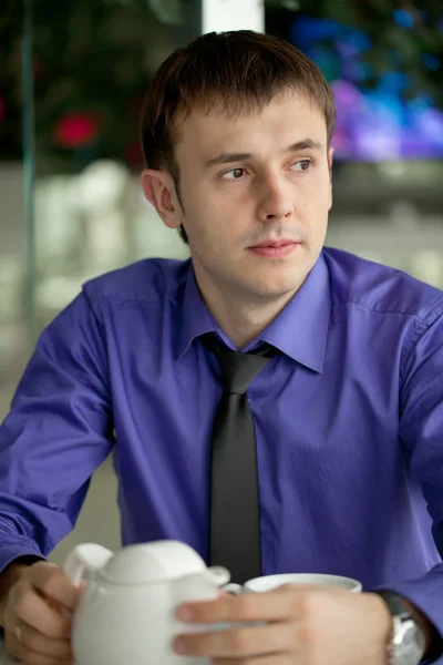 A young man in the office for a cup of tea — Stock Photo, Image