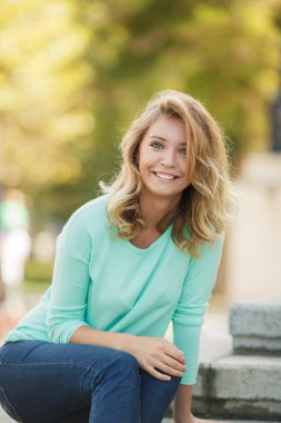 Portret van een jonge mooie lachende blonde vrouw buitenshuis